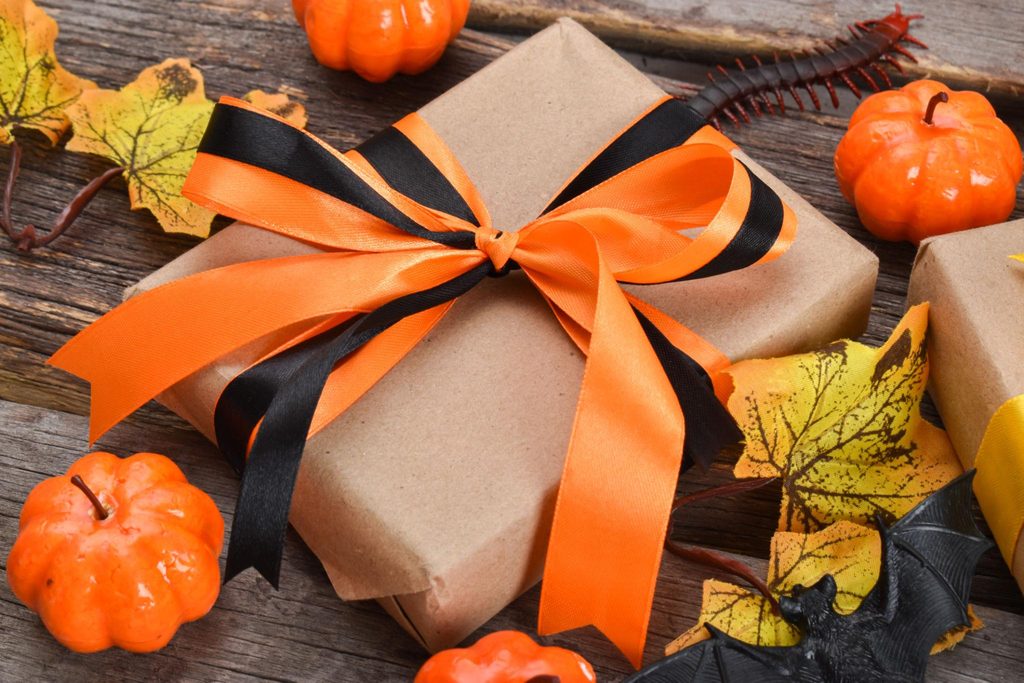Rustic Halloween gift basket with mini pumpkins, kraft paper, orange ribbon and greenery